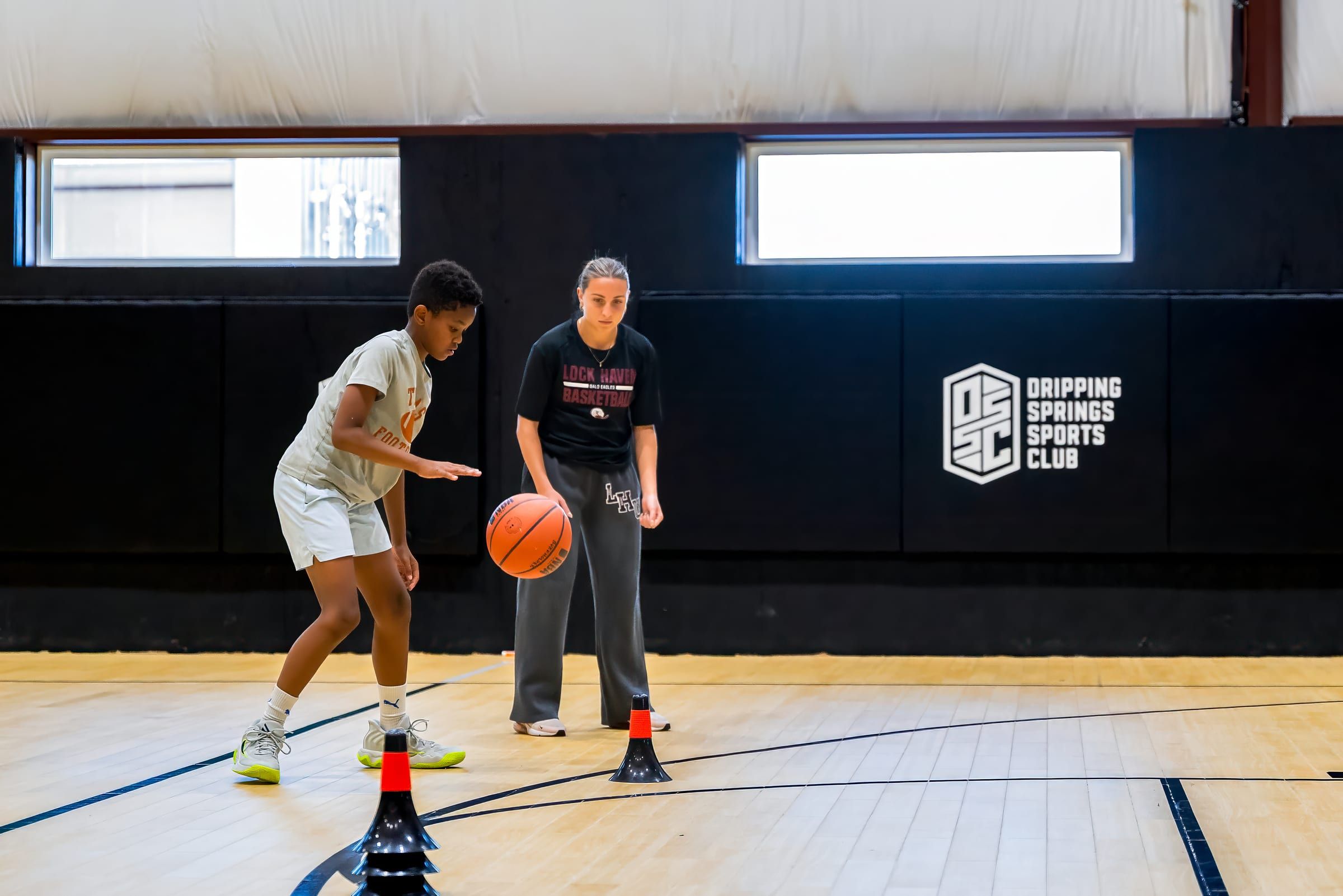 A coach at center court holding a basketball