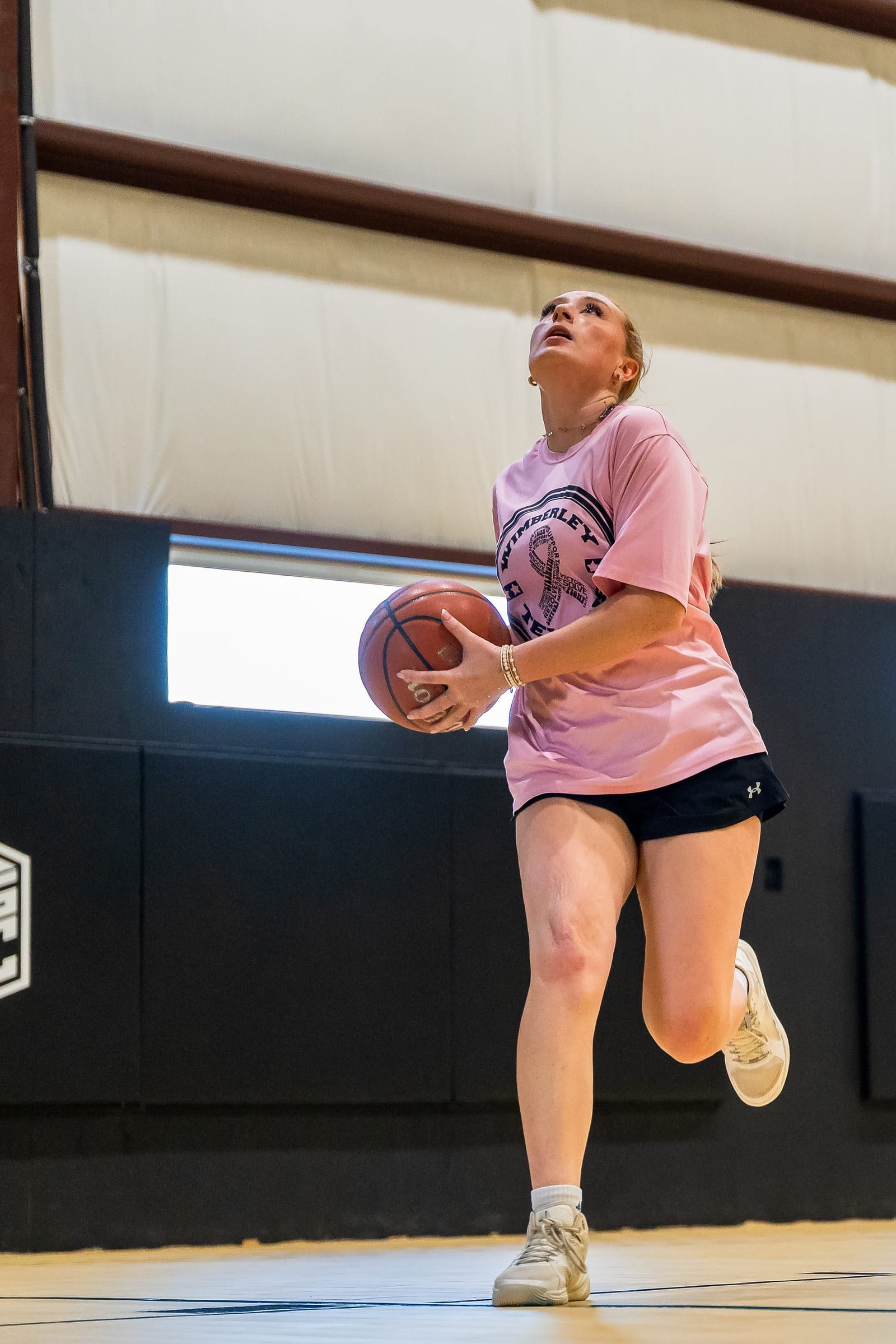 A player holding the ball under the basket, looking up