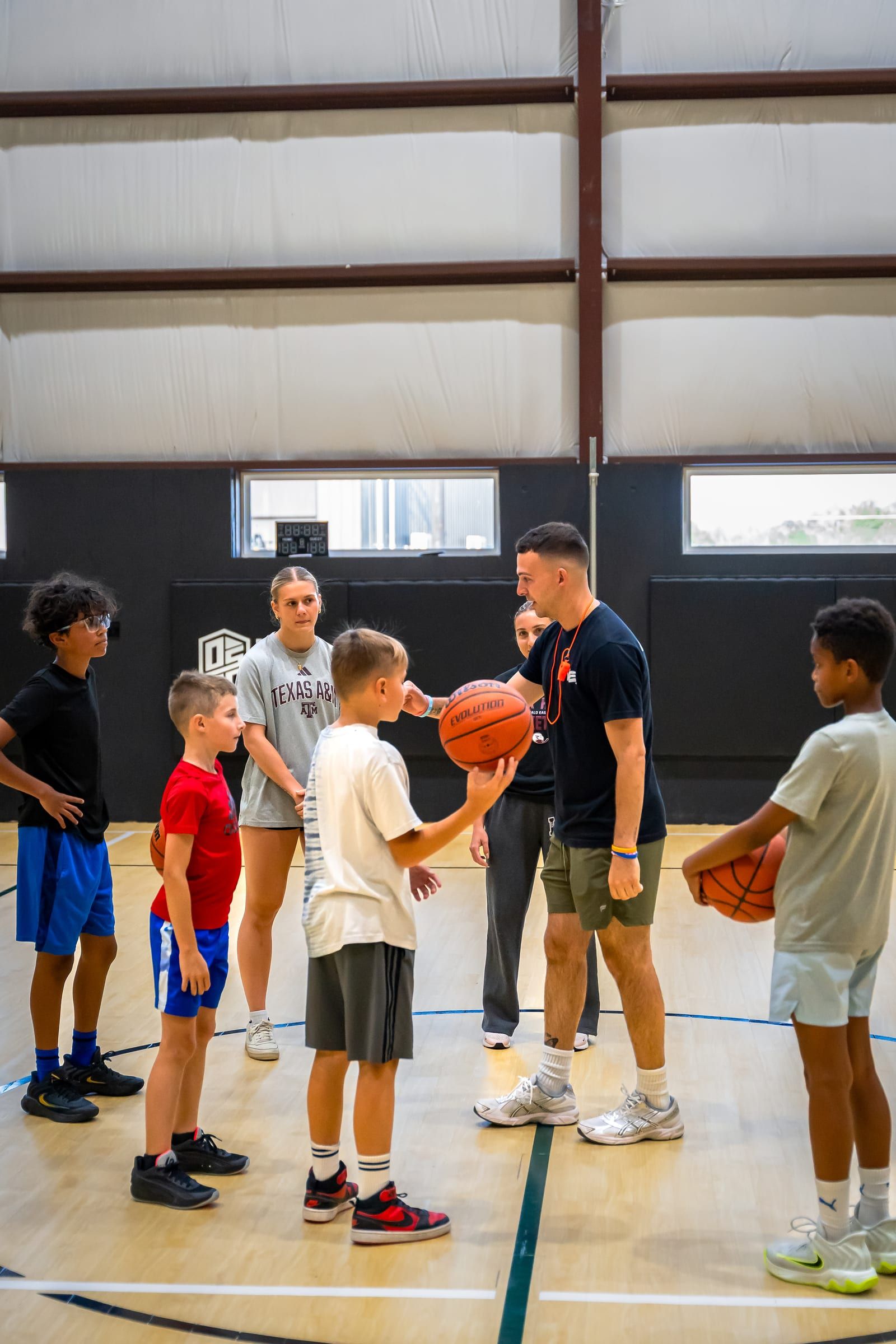 A coach explaining a drill to a huddle of players