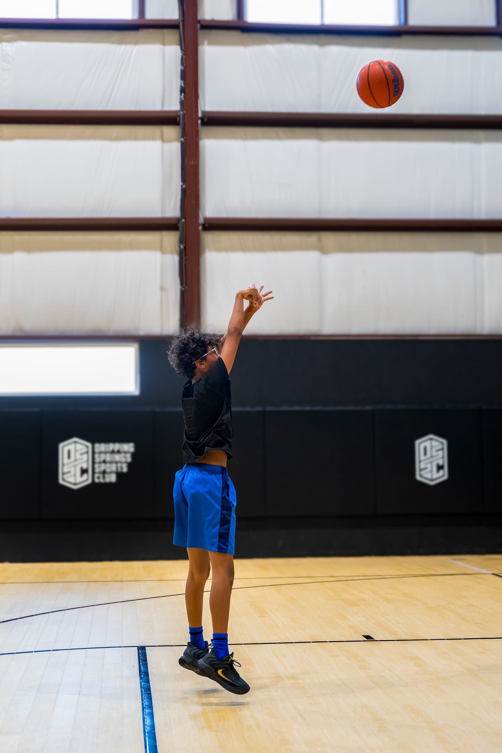 A player following through on a shot, ball in the air