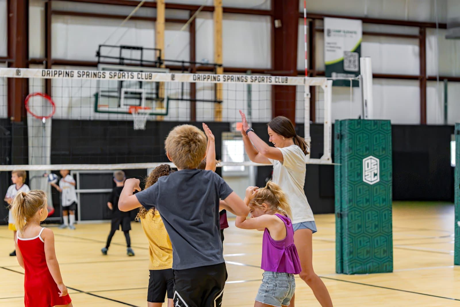 Young campers playing volleyball over a low net