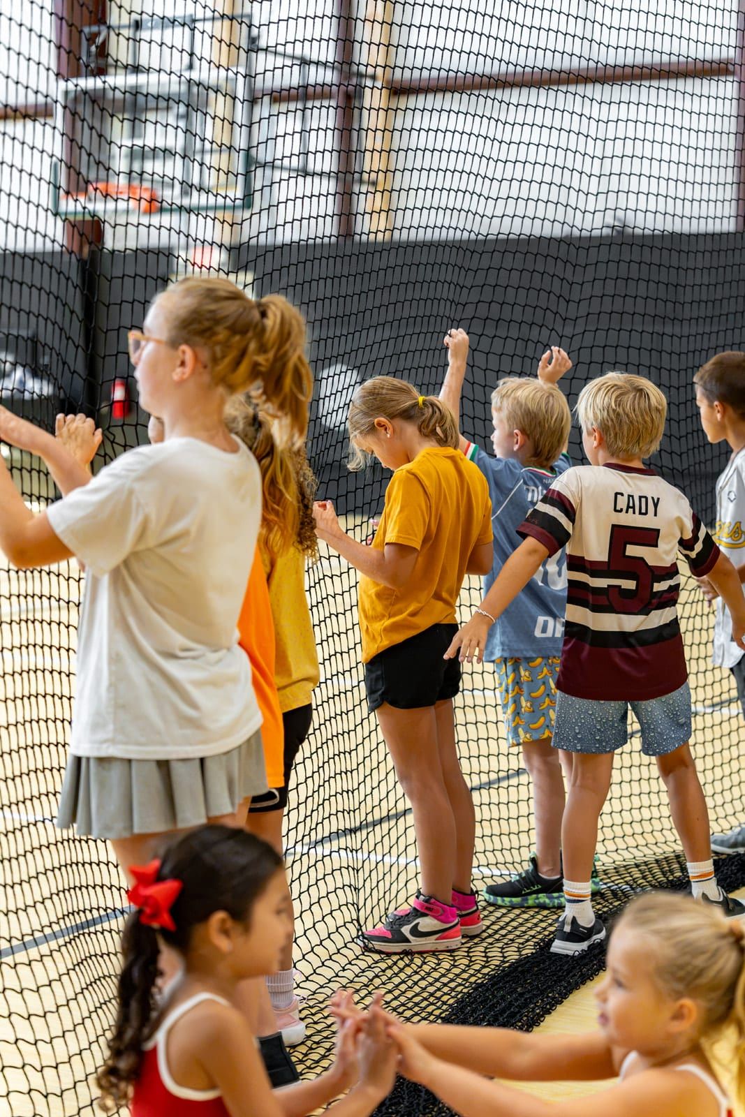 Campers watching from behind the net