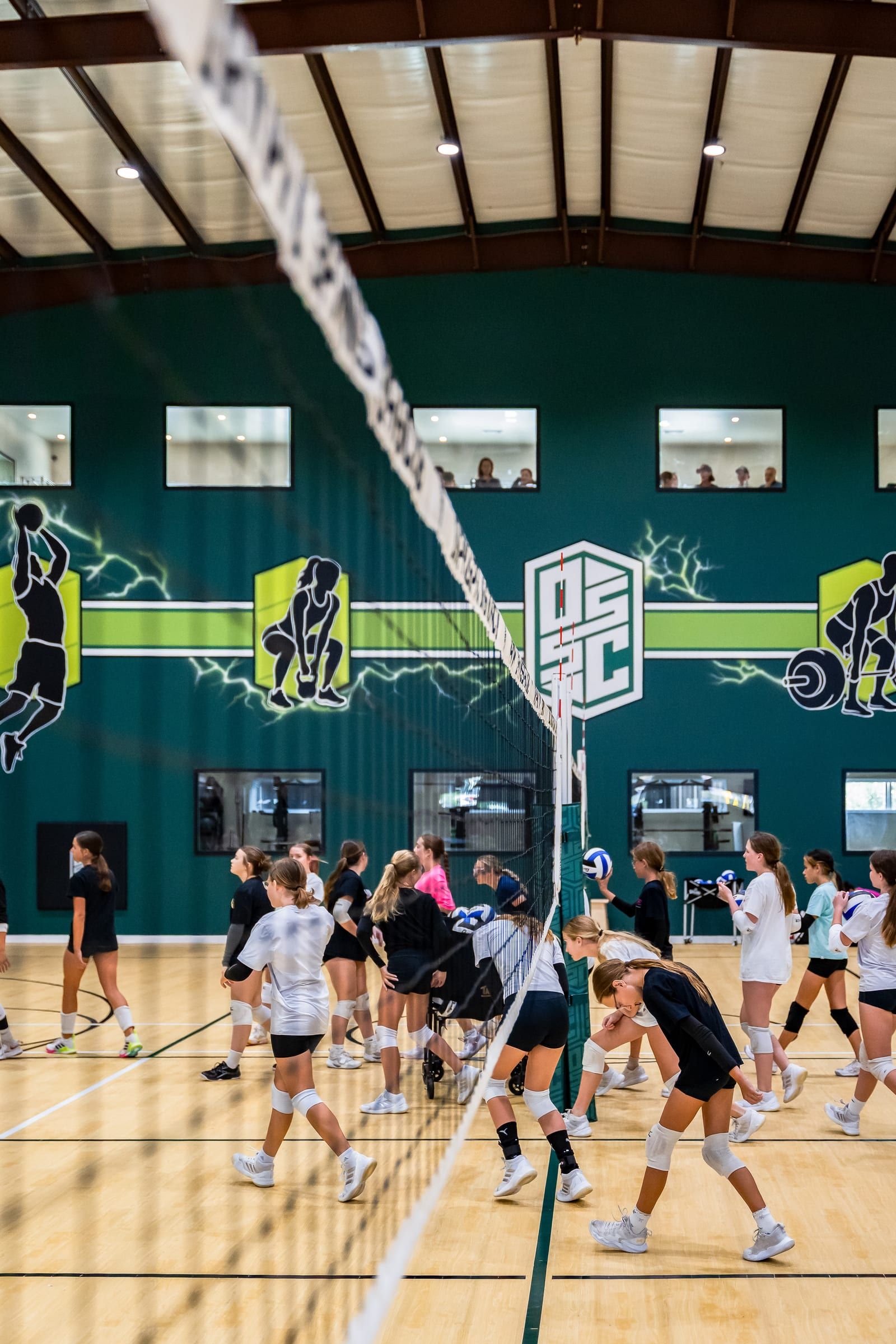 Players warming up at the net under the DSSC mural wall