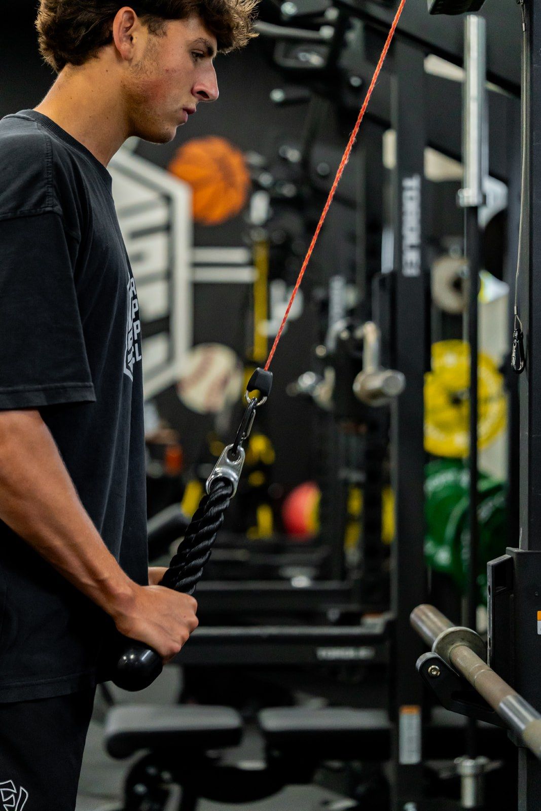 An athlete pulling a cable handle on the rack during a Reach strength session